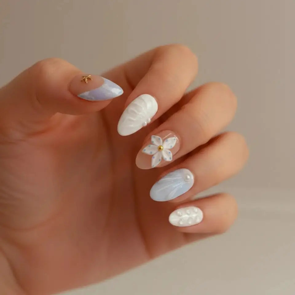 Ocean Bloom Handmade Press-On Nails close-up — short almond shape, nude base with lavender-blue diagonal marble and gold starfish charm on thumb, white 5-petal flower on middle finger, light blue aurora texture on ring finger, pearl dot pinky | MOONLEE