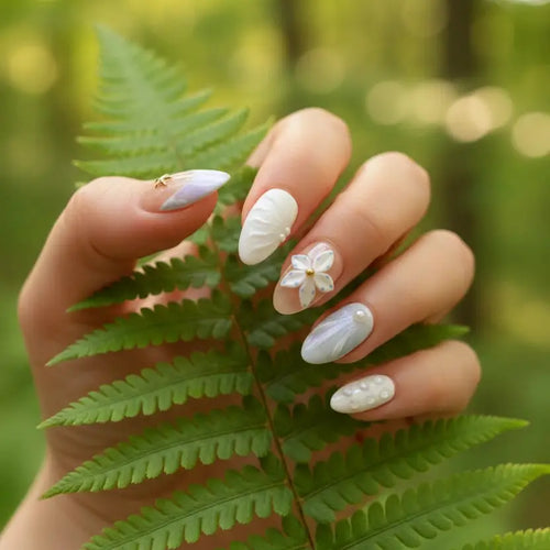 Ocean Bloom Press-On Nails on hand touching green fern leaves in summer forest — short almond nails with 3D starfish charm, white flower, pearl accents, lavender-blue aurora design | MOONLEE