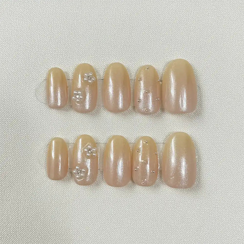 Golden Hour Handmade Press-On Nails — nude gold shimmer with floral accents on short oval shape | MOONLEE